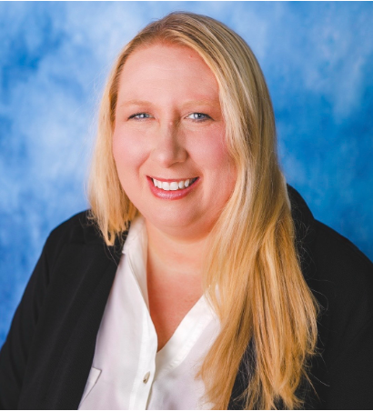 Ashley Tuttle, smiling, in a black blazer and white blouse
